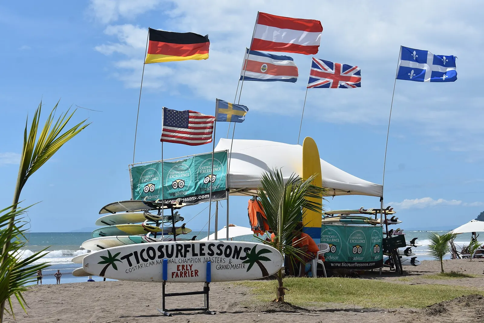 Surf lesson stand with rental boards on the beach at Jacó